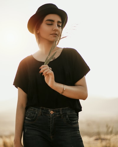 Dressed in a black shirt and blue denim jeans, holding a white umbrella woman
